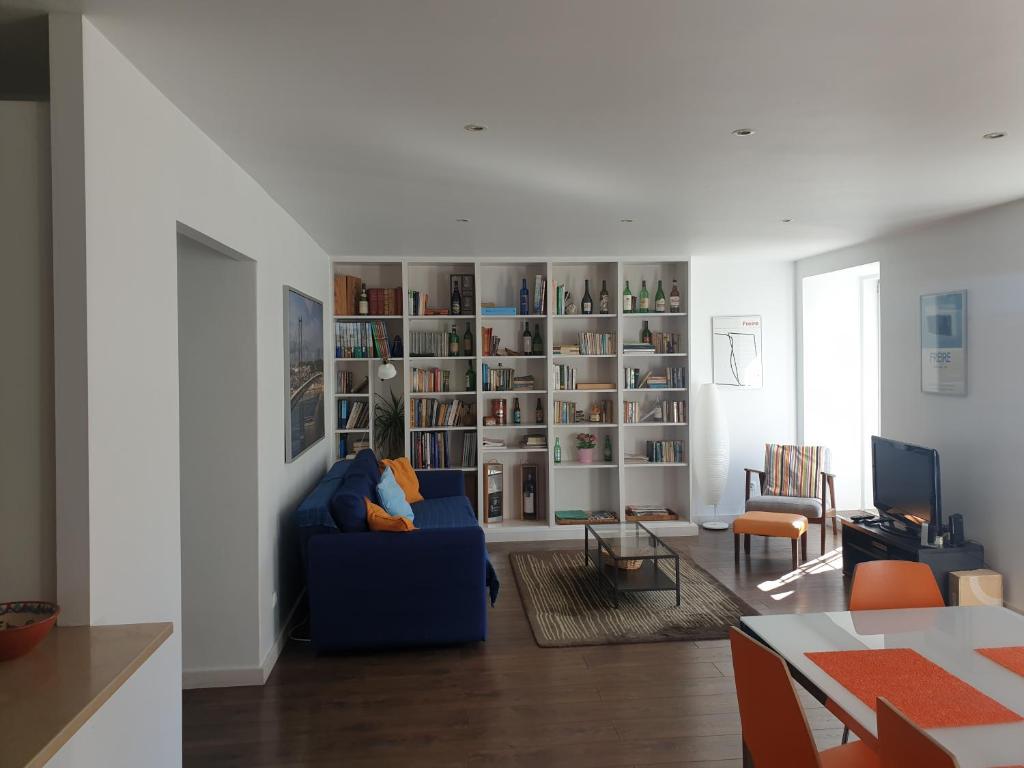 uma sala de estar com um sofá azul e uma estante de livros em Ferragial Central Apartament (DownTown) em Lisboa