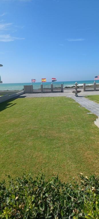 a grassy field with the ocean in the background at Chateau de Marine Boutique Hotel in Struisbaai