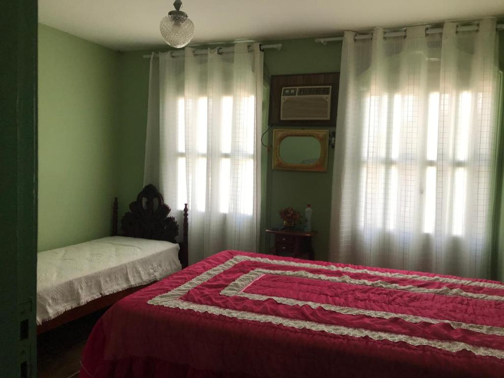 Un dormitorio con una cama con una manta roja. en hospedagem quarto casa da wal en Goiás