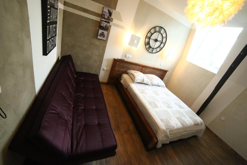 een slaapkamer met 2 bedden en een klok aan de muur bij Hôtel de France in Lens