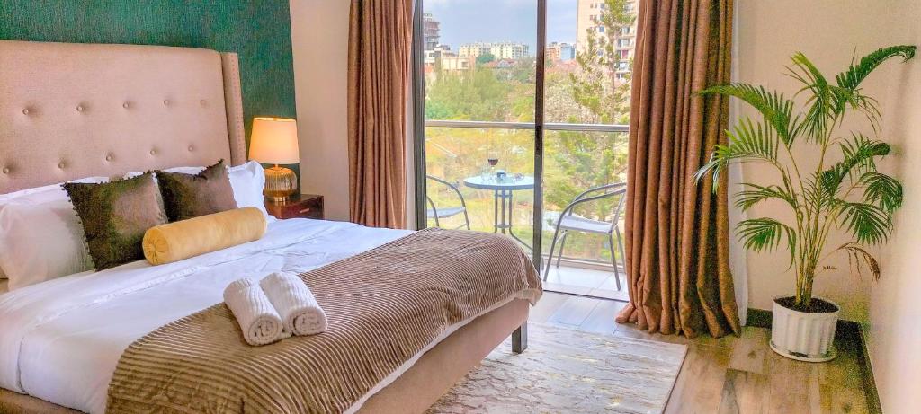 a bedroom with a bed and a large window at Modern luxury one bedroom furnished apartment in Kilimani, Nairobi, Kenya in Nairobi