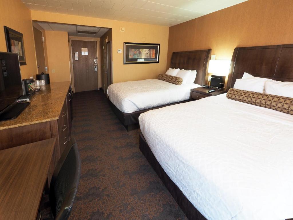 Habitación de hotel con 2 camas y TV de pantalla plana. en Evergreen Resort, en Cadillac