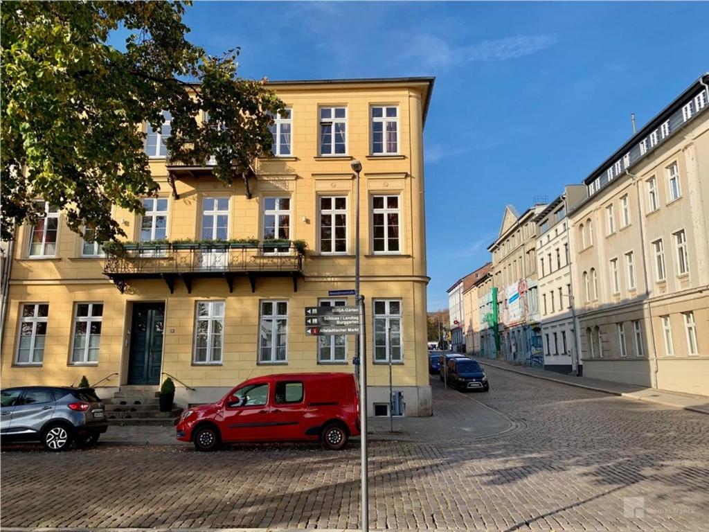 a red van parked in front of a building at Das Ferienapartment Alexandrine direkt am Pfaffenteich mit eigenem Parkplatz in Schwerin