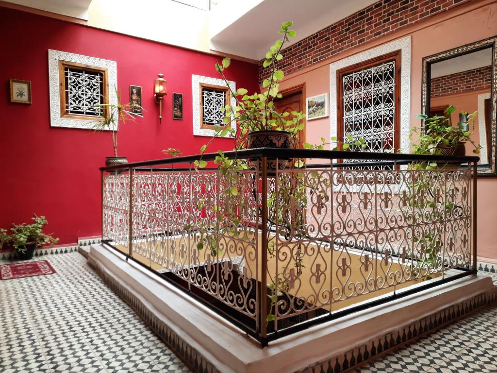 a room with a red wall and a wrought iron fence at Riad 112 in Marrakesh