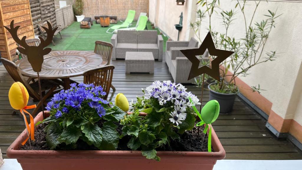 eine Terrasse mit einem Tisch und Blumen in einem Topf in der Unterkunft Gite Edelweiss à Eguisheim in Eguisheim