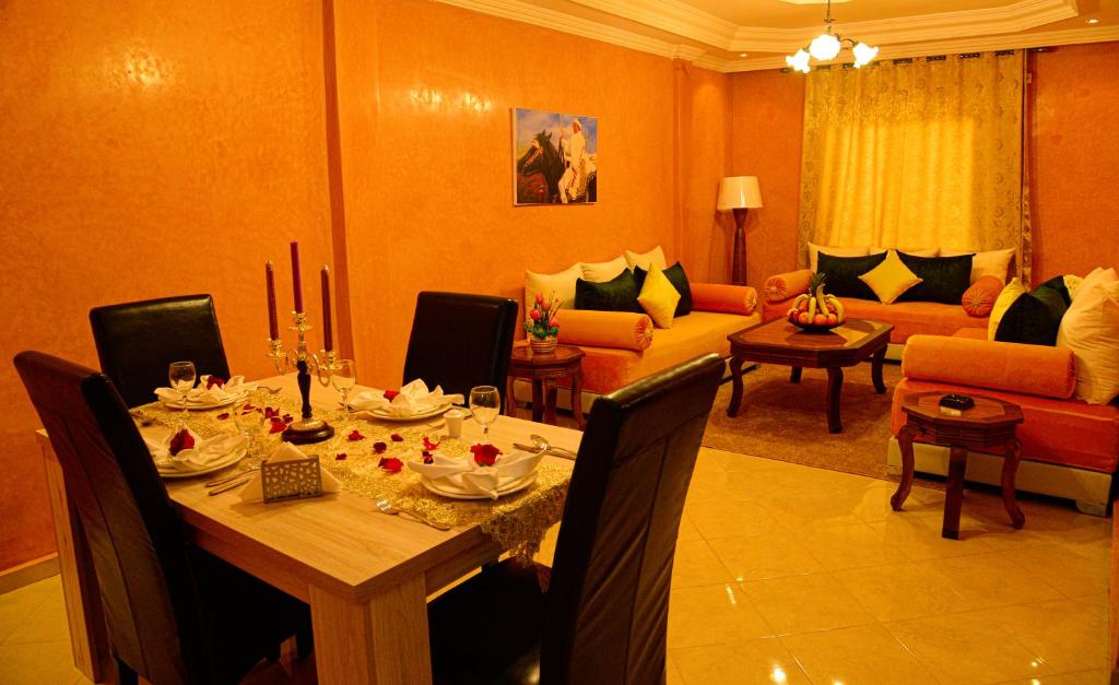 a dining room with a table and a living room at Hôtel La Citta Rossa in Marrakesh