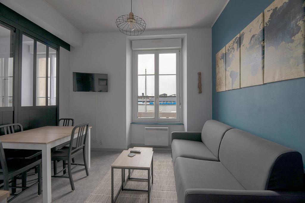 a living room with a couch and a table at Studio cozy proche Intra-Muros in Saint Malo