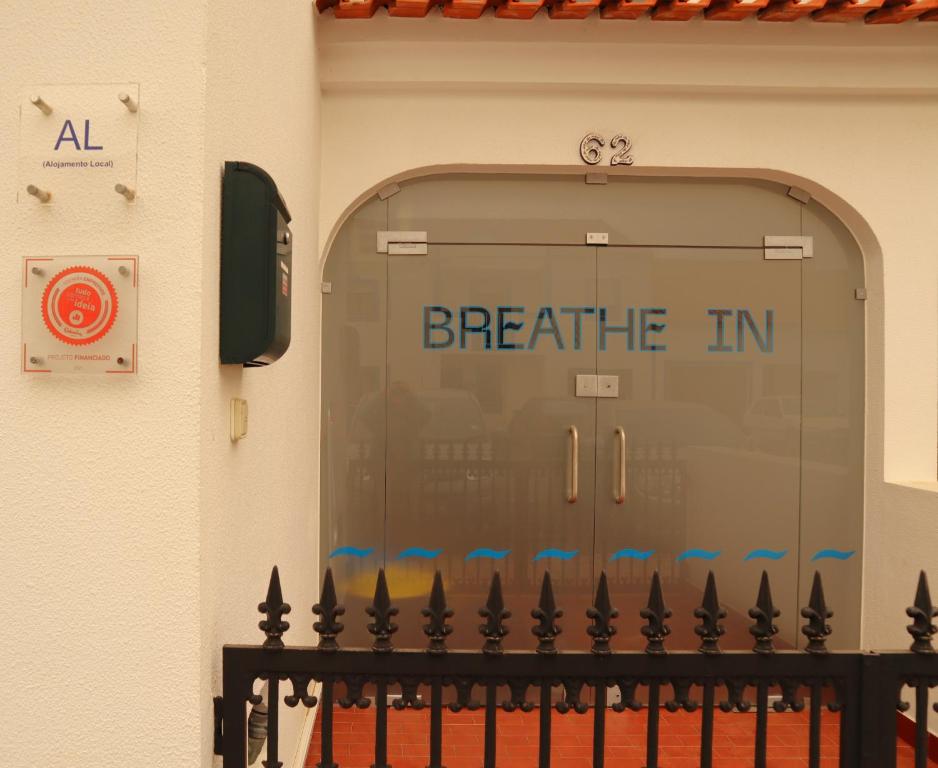 a garage door with the words breathe in written on it at Breathe In in Zambujeira do Mar