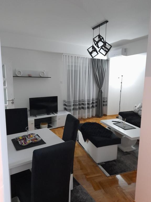 a white living room with a table and a couch at Holiday apartments in Niš