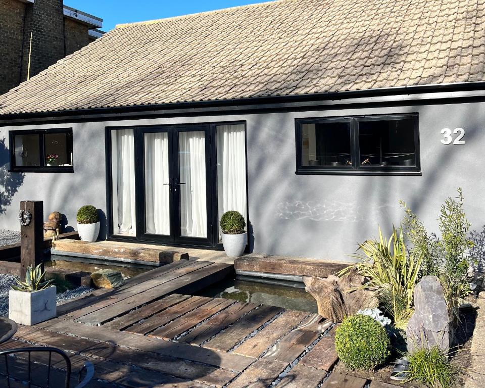 a house with a wooden deck in front of it at Beautiful Beach House in Littlestone-on-Sea