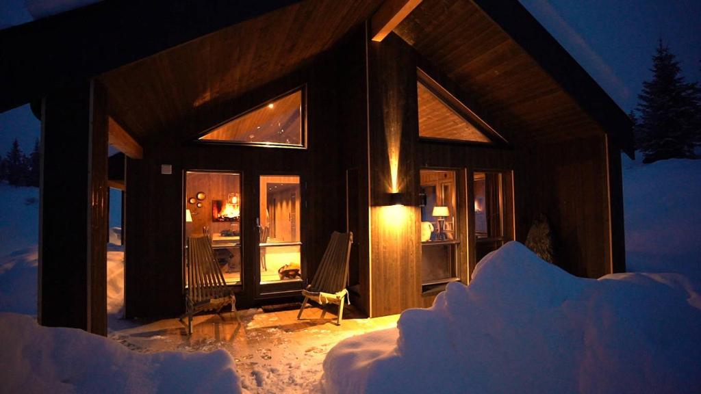 a cabin in the snow at night at Modern unique cabin fantastic location Skeikampen in Svingvoll