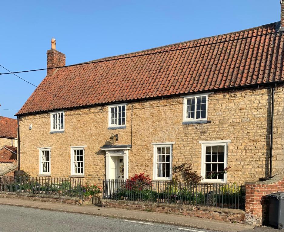 una casa de ladrillo con techo rojo en una calle en Clarke’s Farm en Heighington