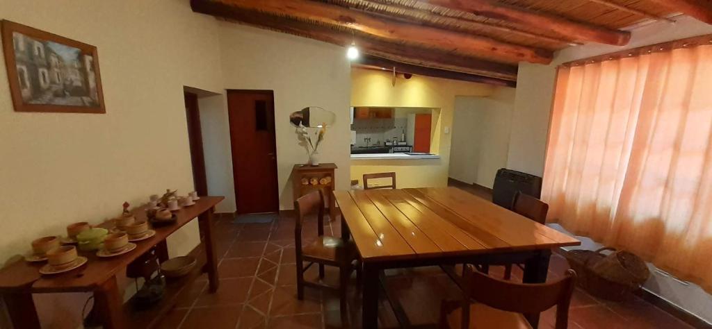 una sala da pranzo con tavolo e sedie in legno di La casa del Norte a Humahuaca