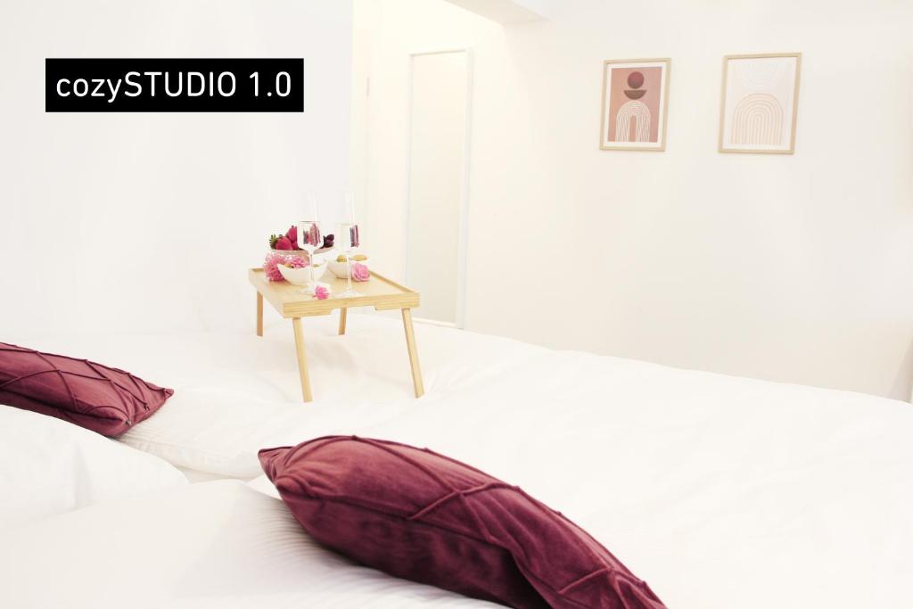 um quarto com duas almofadas numa cama com uma mesa em SECRET HIDEAWAYS cozySTUDIO 2 superior Apartment mit WiFi nahe Uni l Messe l Flughafen l Zoo em Duisburg