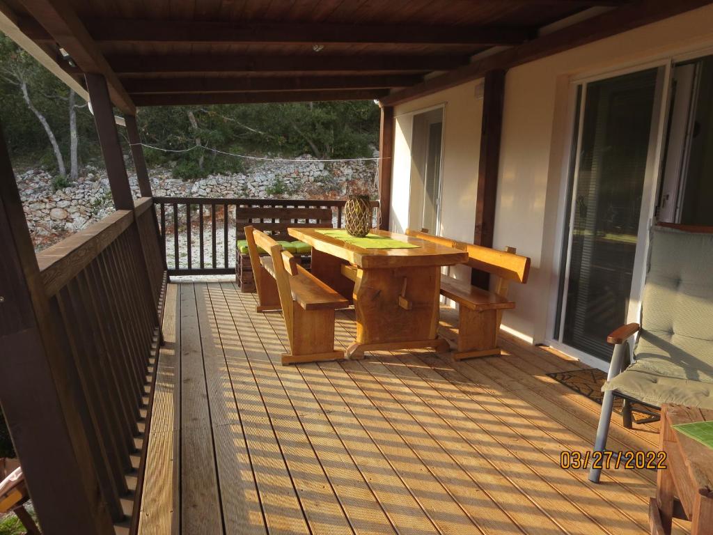 a wooden deck with a table and benches on it at RAVA - Center of the World - place for relaxing in Rava