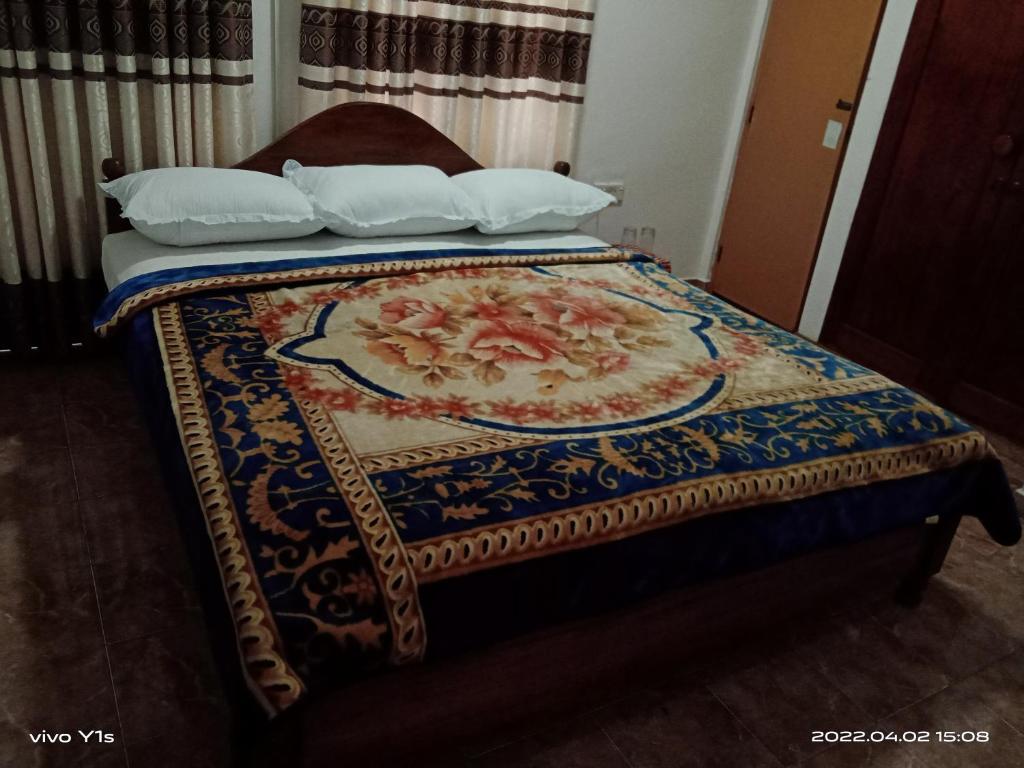 ein Bett mit einer Decke mit zwei Kissen in der Unterkunft 'Franklyn', Homestay in Kalutara