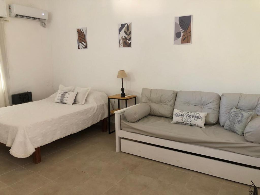 een woonkamer met een bank en een bed bij Acogedor departamento bien ubicado in Concordia