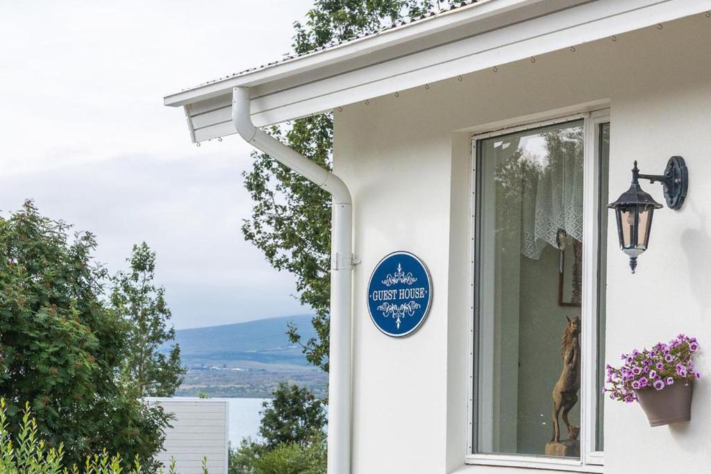 un cartello blu sul lato di una casa di North Inn - Guesthouse and Cabin ad Akureyri