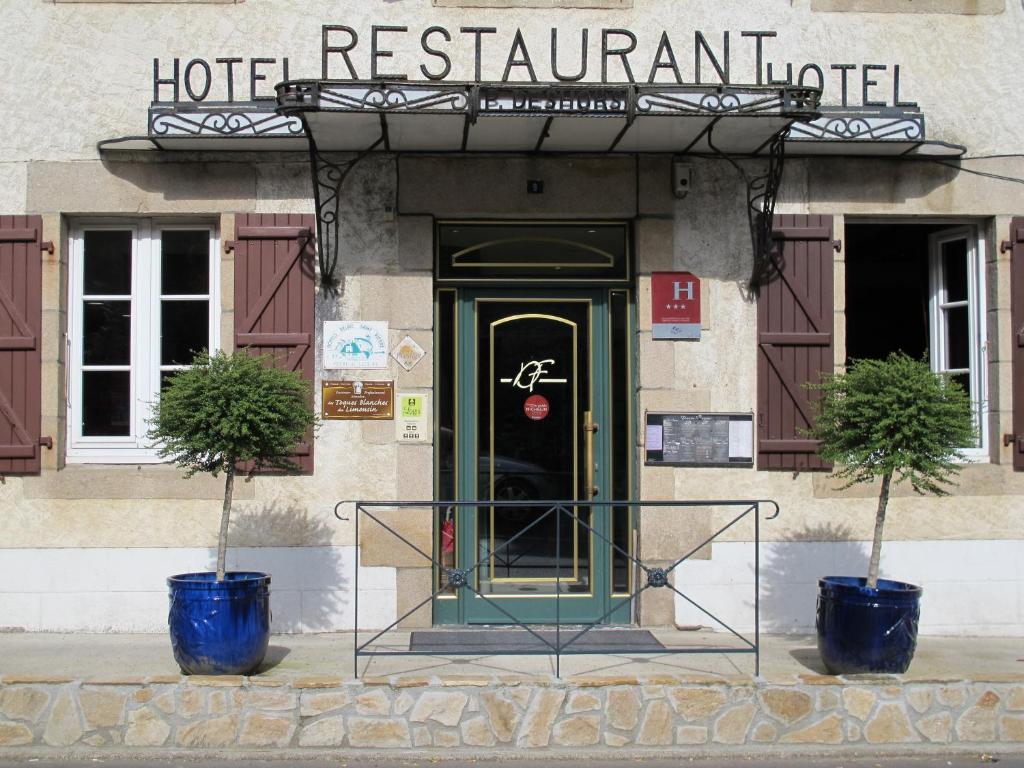un hôtel avec deux plantes en pot devant une porte dans l'établissement Logis Deshors-Foujanet, à Chamboulive