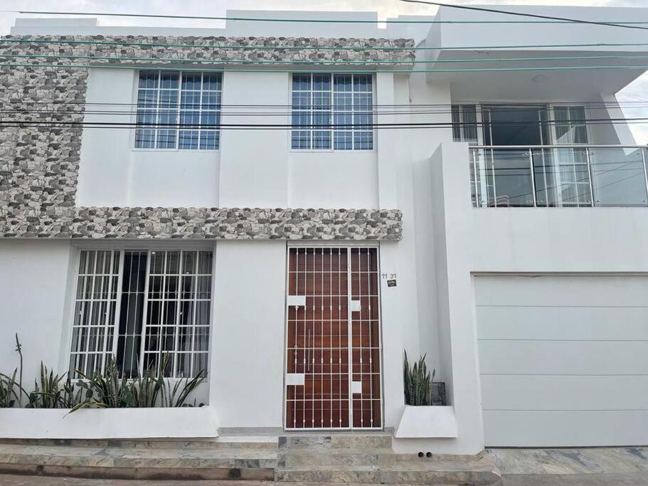 una casa bianca con una porta rossa e un garage di Casa Vacacional Villanueva a Villanueva