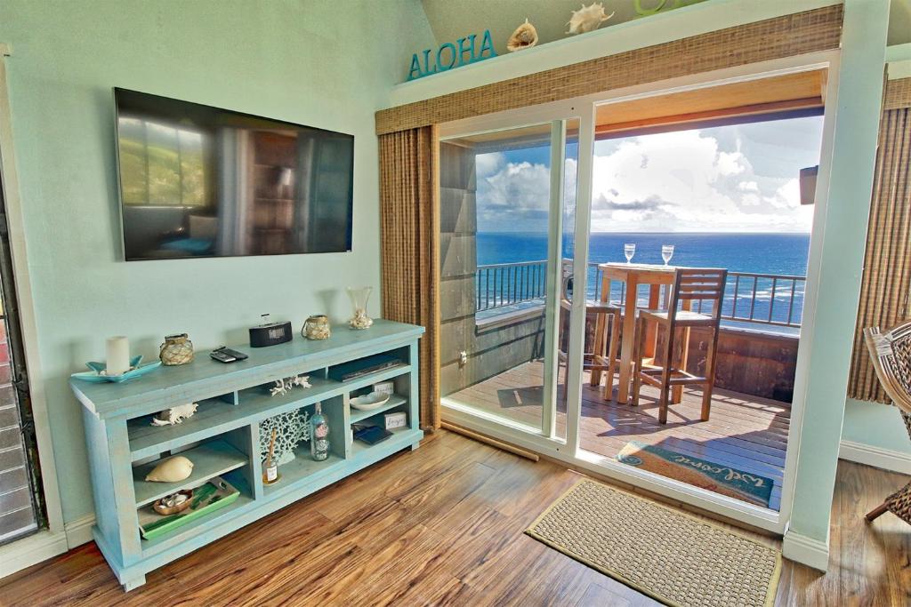 a room with a balcony with a view of the ocean at Sealodge G9 in Princeville