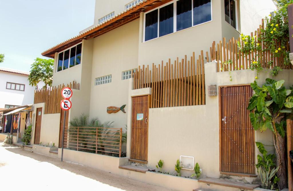 un bâtiment avec des portes en bois et une clôture dans l'établissement Recanto da sereia, à Jericoacoara