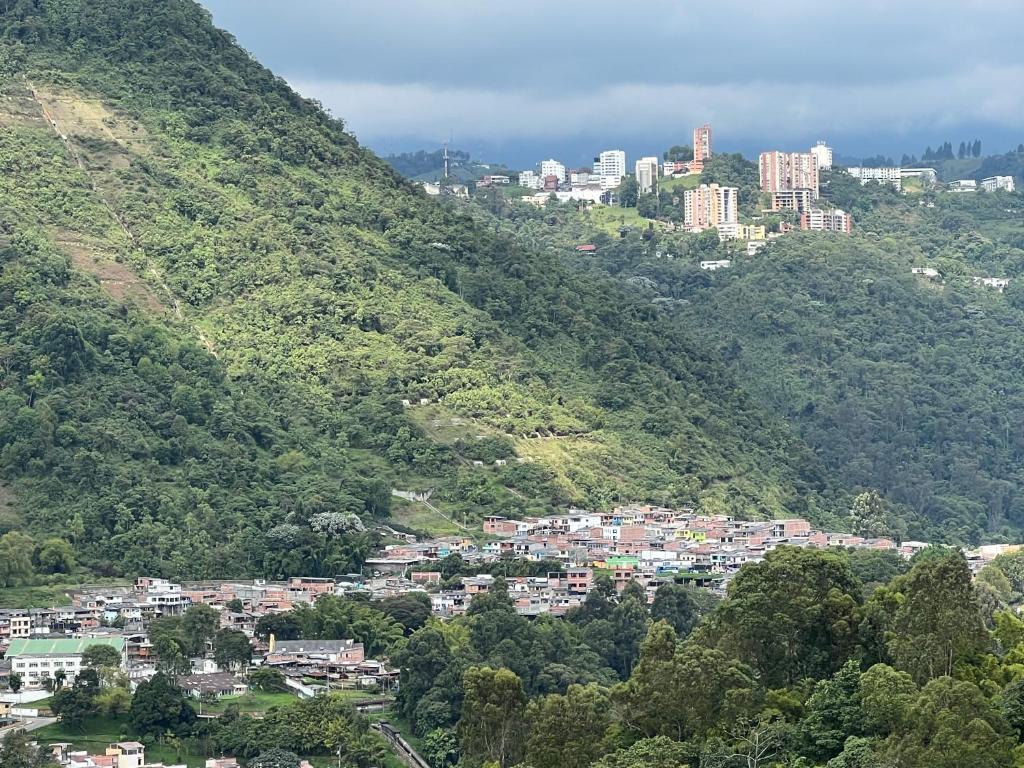 - une vue sur une ville sur une montagne dans l'établissement APARTAMENTO CON VISTA A LAS MONTAÑAS CAPACIDAD 6 PERSONAS SECTOR VILLAMARIA, à Villamaría