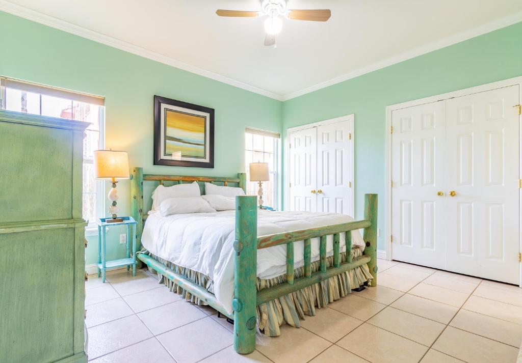 1 dormitorio con 1 cama con paredes verdes en Moon Dancer Condominiums, en South Padre Island