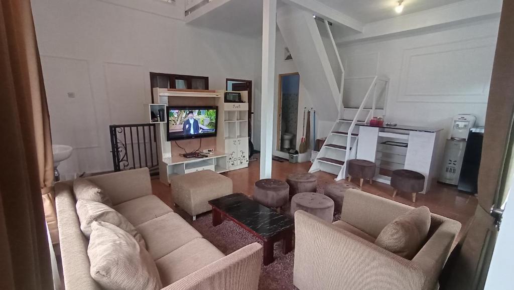 - un salon avec deux canapés et une télévision dans l'établissement DIENG GHUZY HOUSE syariah family room, à Wonosobo