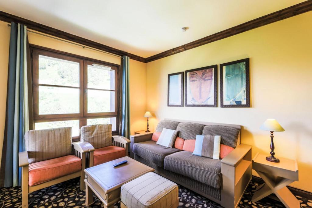 un salon avec un canapé et une table dans l'établissement Résidence Les Arcs 1950 Le Village - maeva Home - Appartement 3 pièces 6 personnes Sélection - Vue directe sur le Mont Blanc MAE-4037, à Bourg-Saint-Maurice