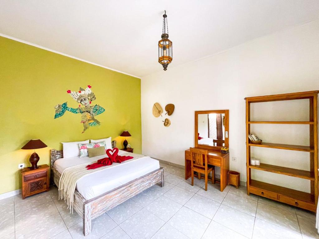 a bedroom with a bed with a red bow on it at Enak Bungalow in Amed