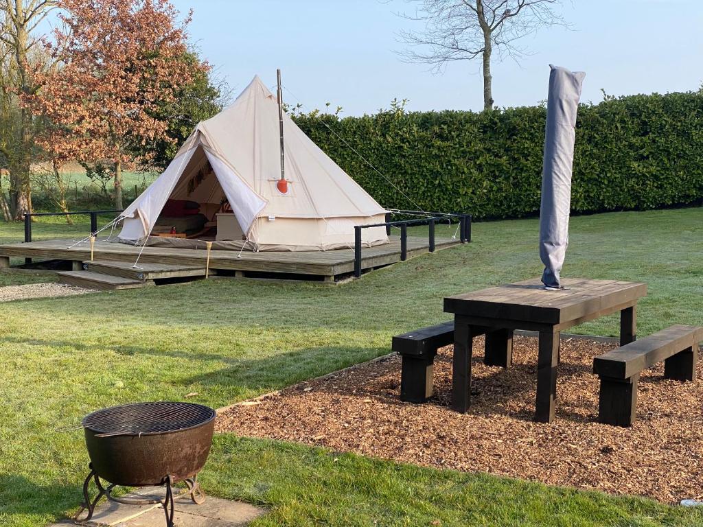 a tent and a picnic table and a grill at Glen Farm Glamping in Cromer