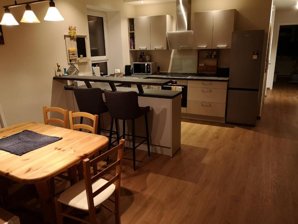 une cuisine avec une table en bois, une table et des chaises dans l'établissement gemütliches Sandsteinhaus, à Buergstadt