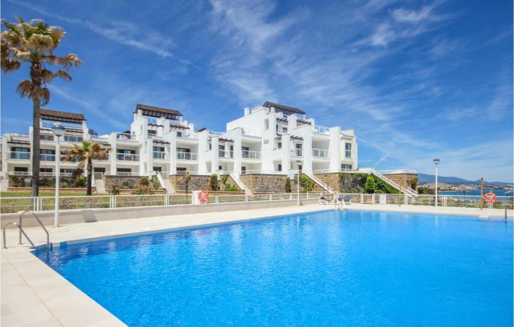 un hôtel avec une piscine en face d'un bâtiment dans l'établissement Cozy Apartment In Casares With House Sea View, à Casares