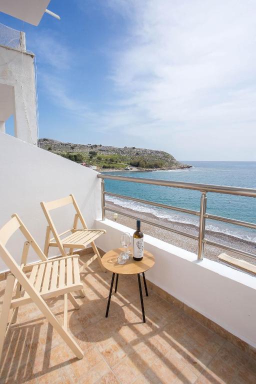a balcony with two chairs and a table and the ocean at Haraki Bay Loft (by haris) in Haraki