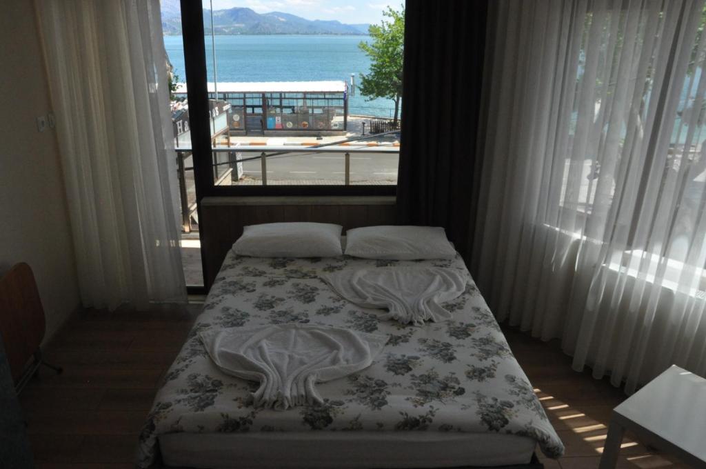 a bedroom with a bed with a view of the ocean at Choo Choo Pansiyon in Isparta