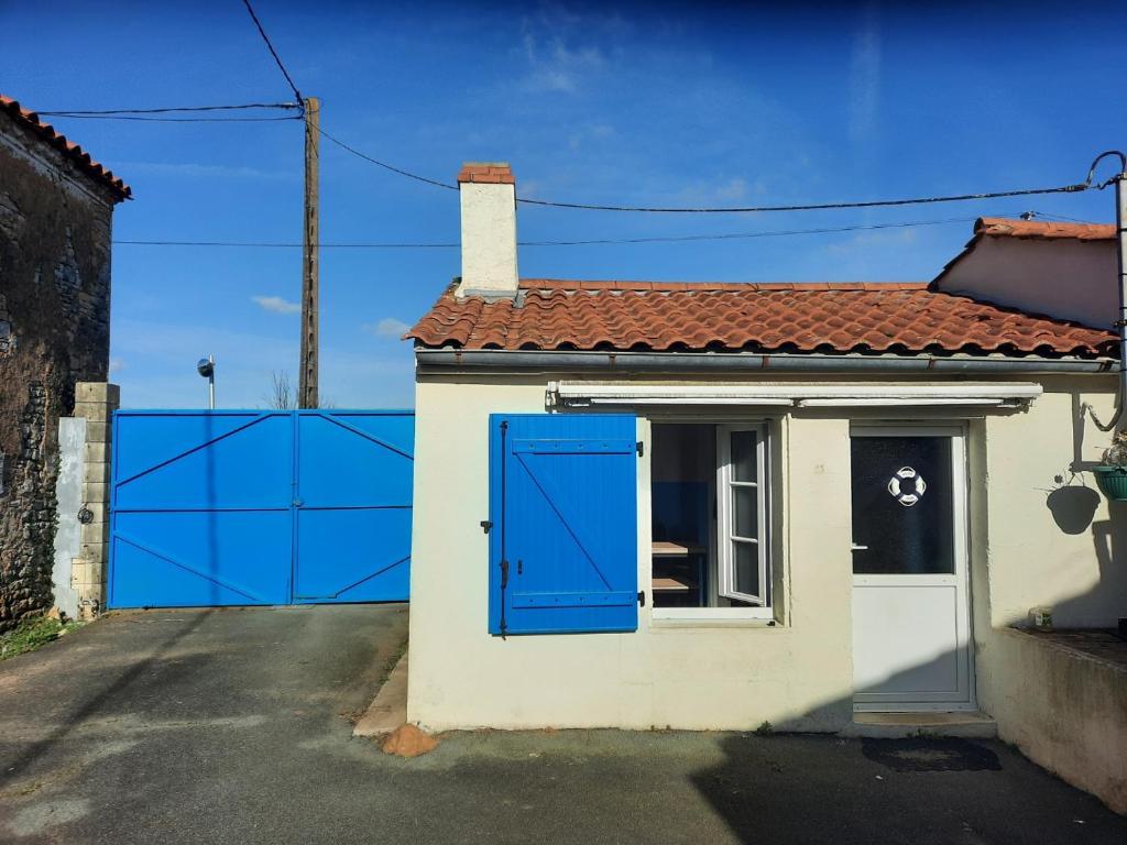 une maison avec une porte bleue et une clôture dans l'établissement GITE ENTRE TERRE ET MER, à Mareuil-sur-Lay