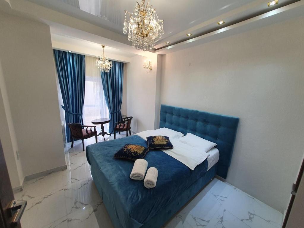 a bedroom with a blue bed with two towels on it at Bella Donna Hotel in Chişinău