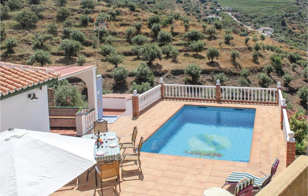 a villa with a swimming pool and a table and chairs at Beautiful Home In Torrox Costa With 3 Bedrooms, Wifi And Outdoor Swimming Pool in Torrox Costa