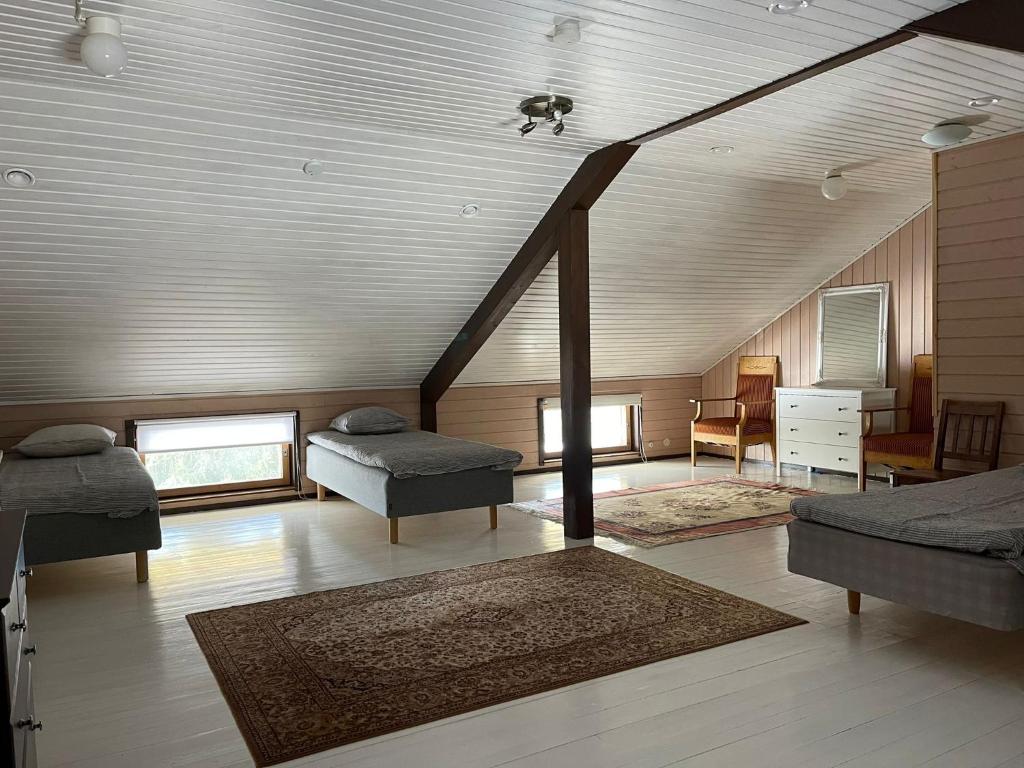 a living room with two beds and a staircase at Mentulan Villa in Lappeenranta