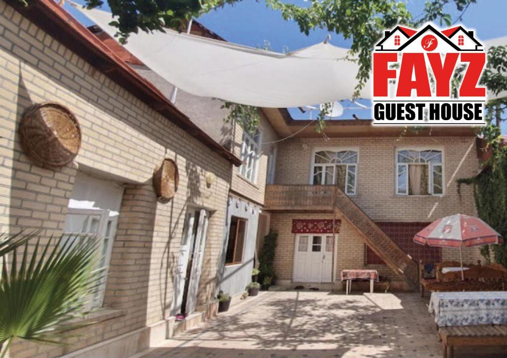 a house with a guest house with an umbrella at Fayz Guest House in Samarkand