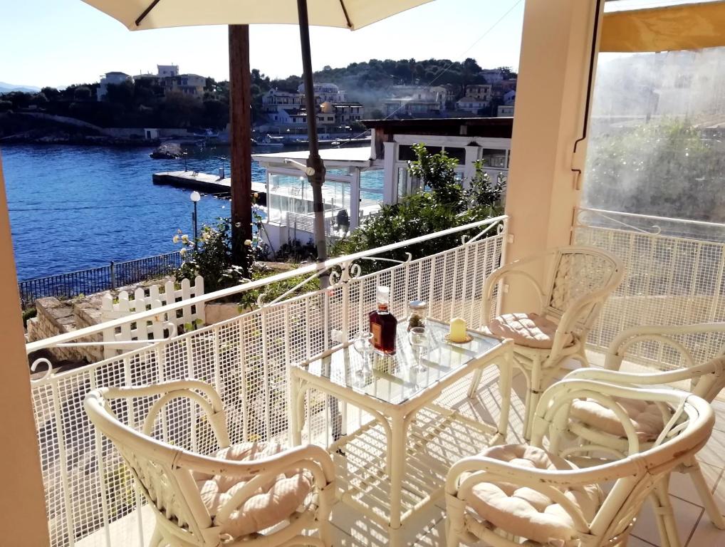 a table and chairs on a balcony with a view of the water at Sea Rose in Kassiopi