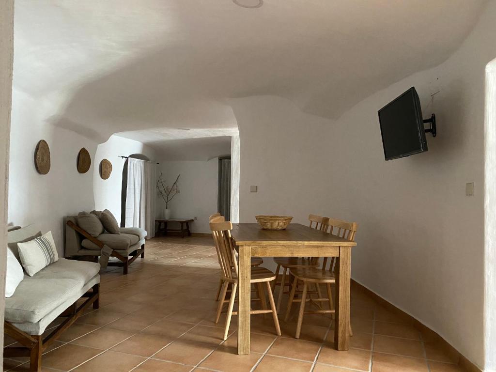 a living room with a table and chairs and a couch at Cueva de Ramón y Elvira in Cuevas del Campo