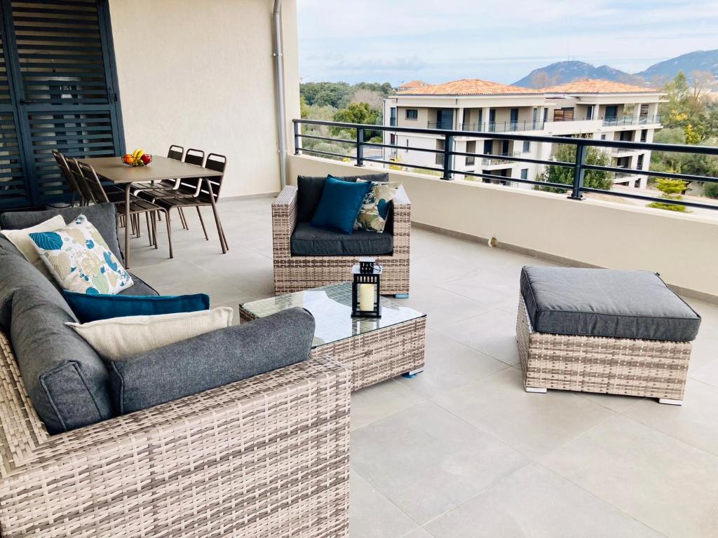d'un balcon avec des canapés, une table et une table. dans l'établissement Sognu di Serena - Superbe appartement avec parking gratuit sur place, à Porto-Vecchio