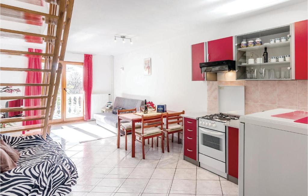 a kitchen and dining room with red cabinets and a table at Cozy Apartment In Vodnjan With Wifi in Vodnjan
