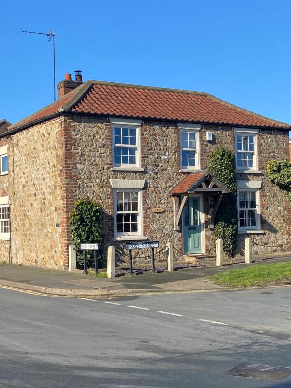 a brick building with a bench in front of it at Ivy House, three bed cottage, parking garden in Skipsea