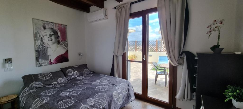 a bedroom with a bed and a door to a patio at Pambi House in Quartu SantʼElena