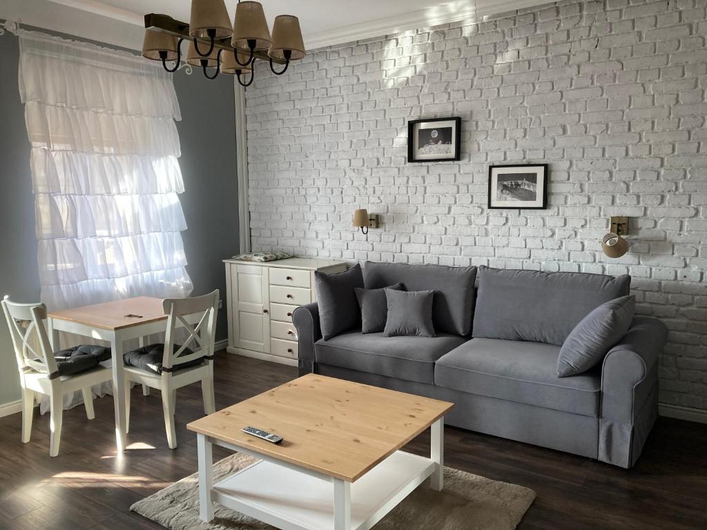 a living room with a couch and a table at Villa Akant - Apartamenty w Karkonoszach in Piechowice