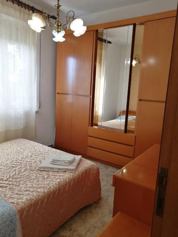 sypialnia z łóżkiem, komodą i lustrem w obiekcie Casa Giardino sul Mare w mieście Grottammare
