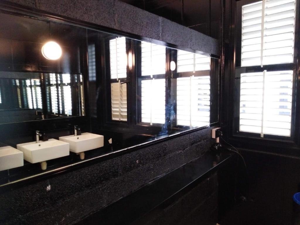 a bathroom with three sinks and a mirror at Wink at Mosque Street in Singapore